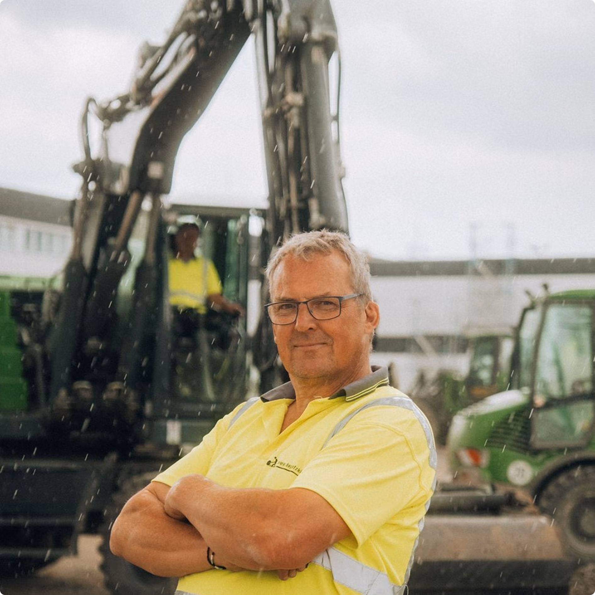 Mitarbeiter mit verschränkten Armen vor einem Bagger