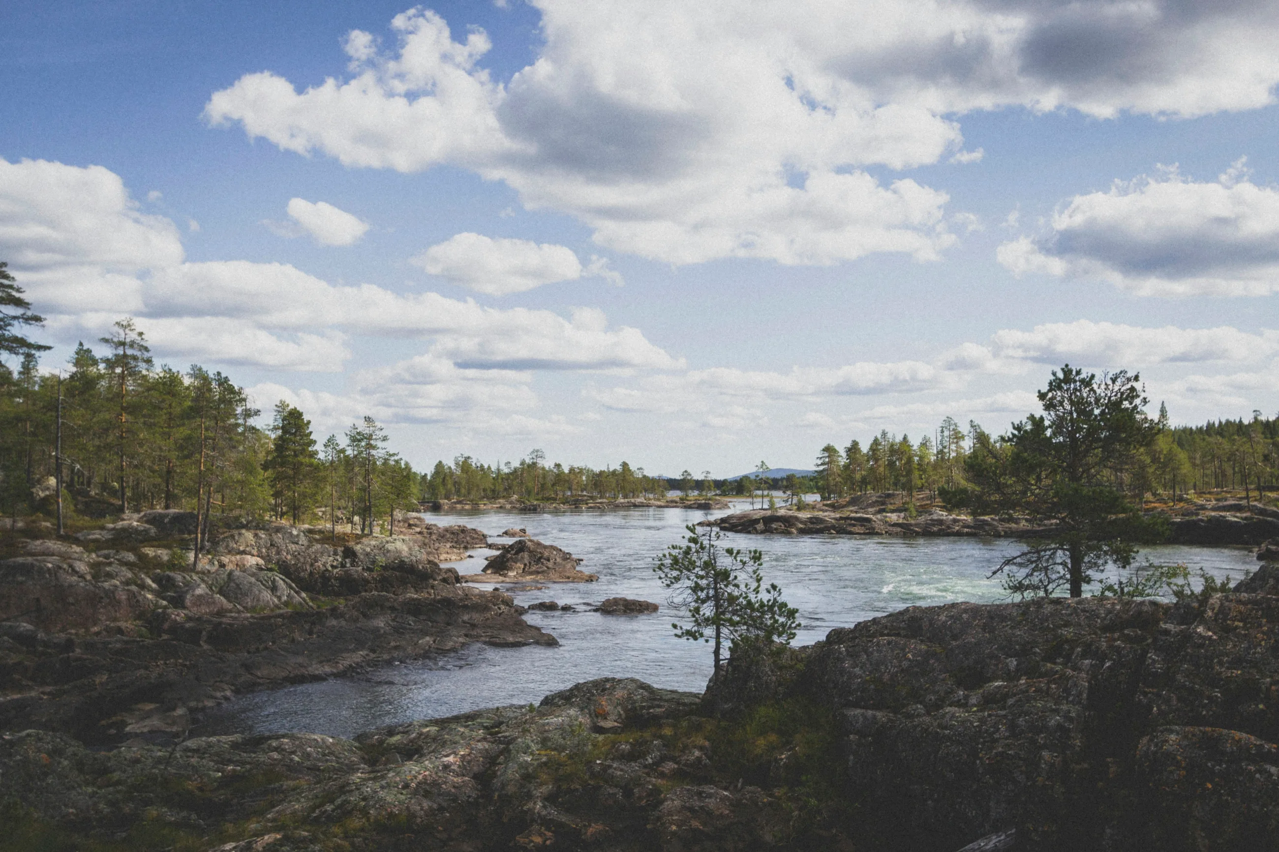 A wide Swedish river running over rocky shallows at Trollforsen on the Piteälven, northern Sweden