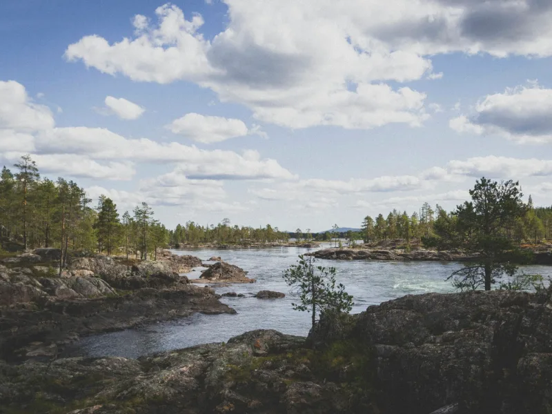 A wide Swedish river running over rocky shallows