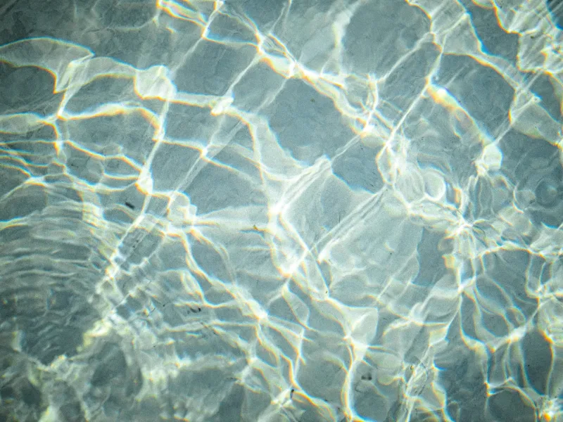 Sunlight refracting through clear shallow water