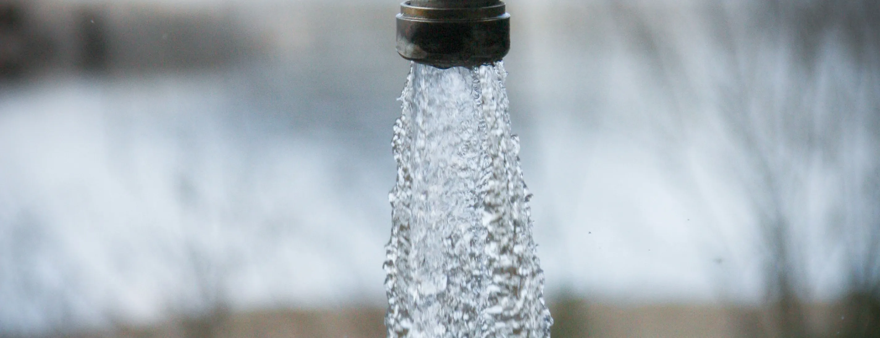 Clear water running from a spout above a lake