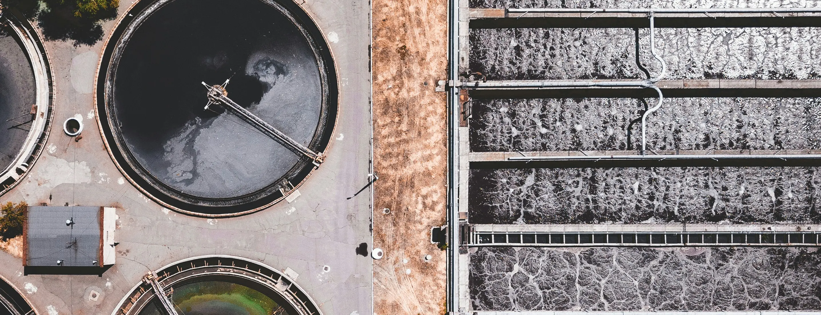 Aerial view of a water treatment plant, its circular clarifiers and rectangular filter beds seen from above