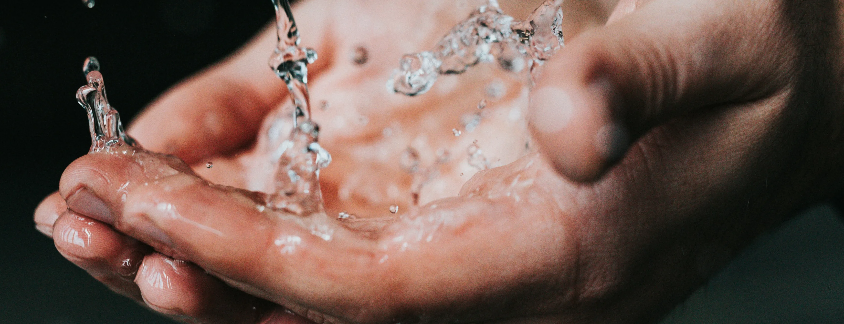 Water running into a pair of cupped hands, the reason water quality is monitored