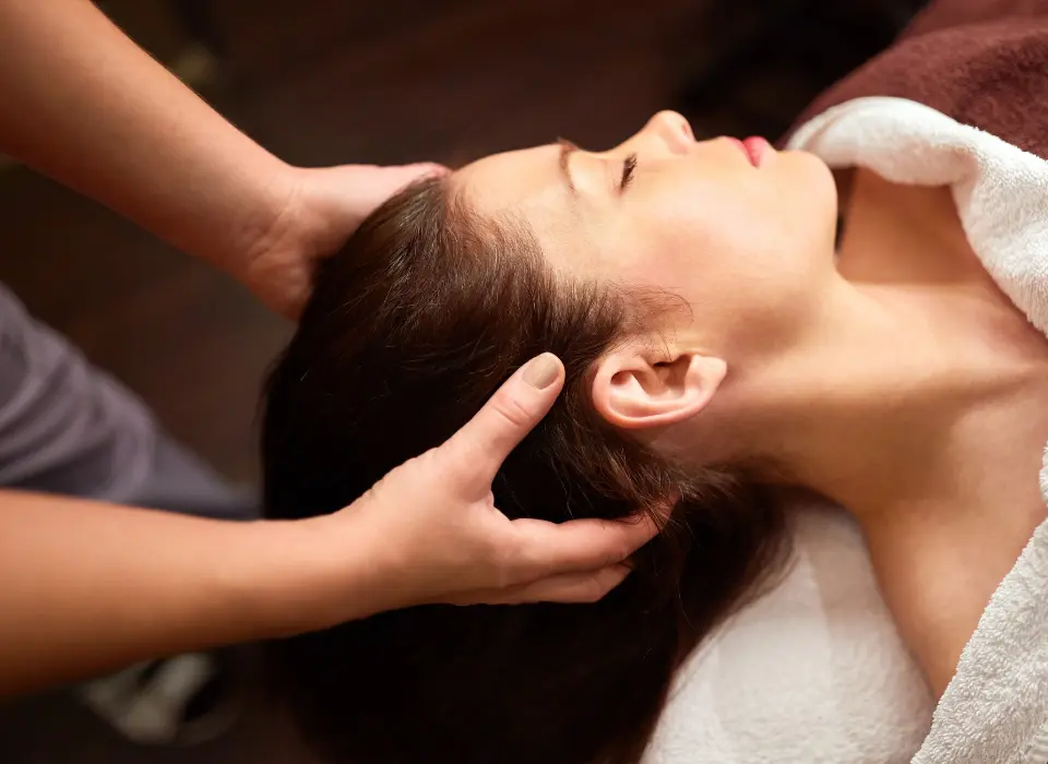 Serviettes roulées, bougies allumées et orchidée blanche dans un cabinet de massage