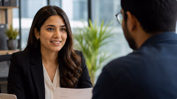 HR professional reviewing documents during a candidate meeting in a modern office