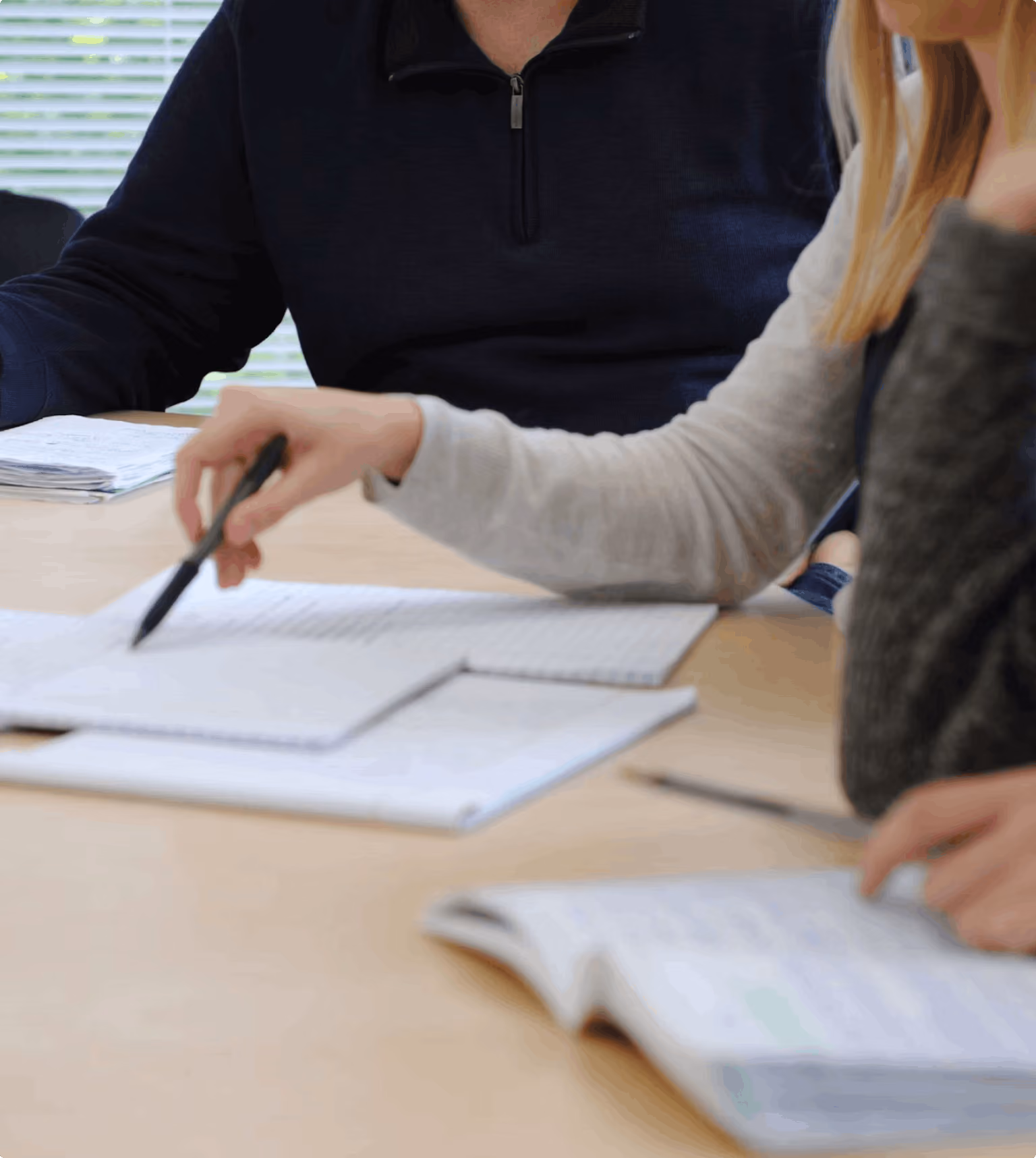 Two professionals reviewing compensation documents and data together at a desk