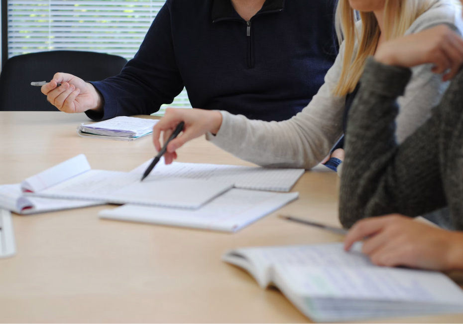 Two professionals reviewing compensation documents and data together at a desk