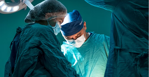 Surgical team performing an operation under bright theatre lights