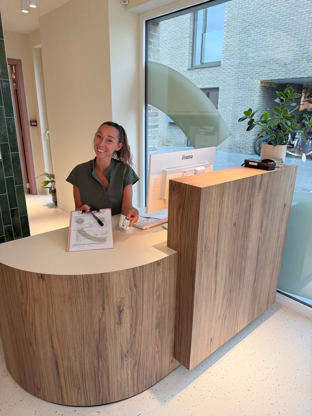 Medewerkster van Kinderlach aan de balie van de praktijk