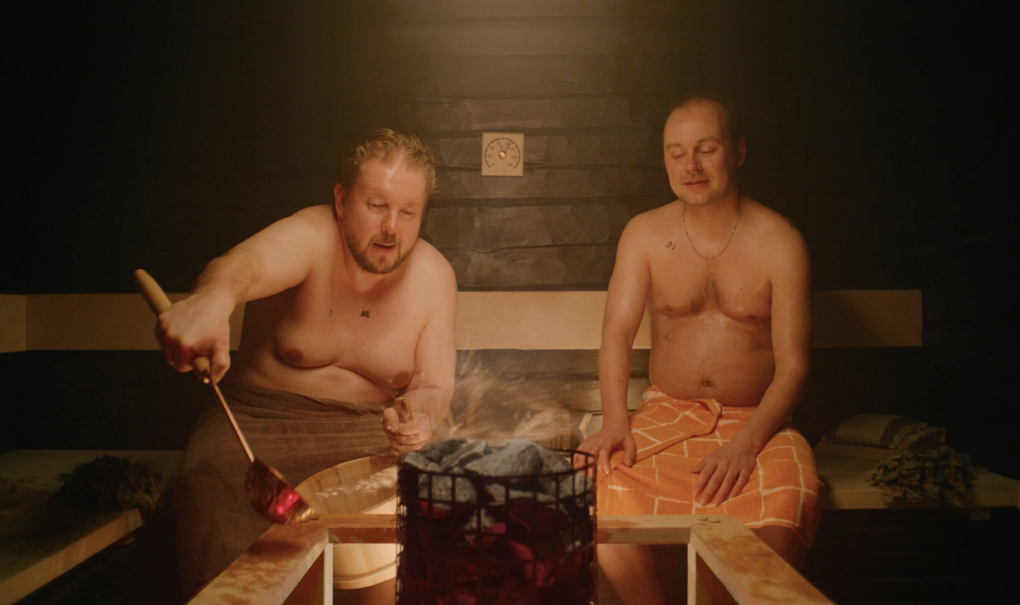 Two persons sitting in sauna