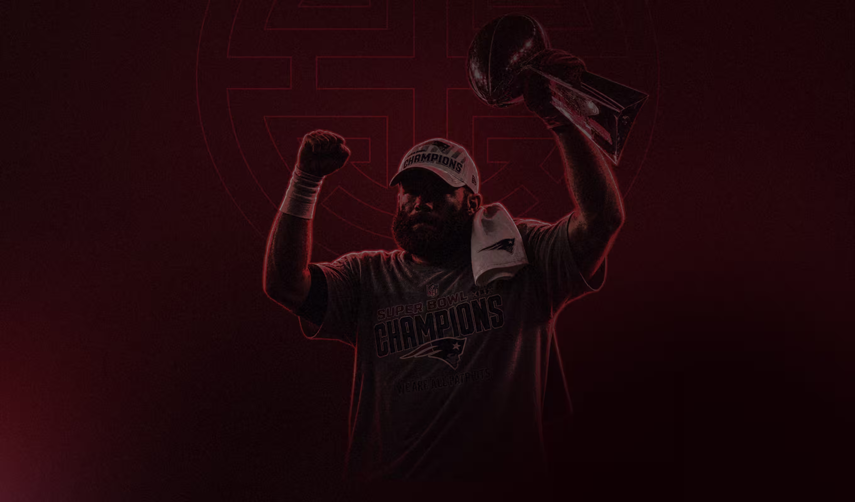 Football player wearing Super Bowl champions shirt holding trophy and raising fist in celebration.