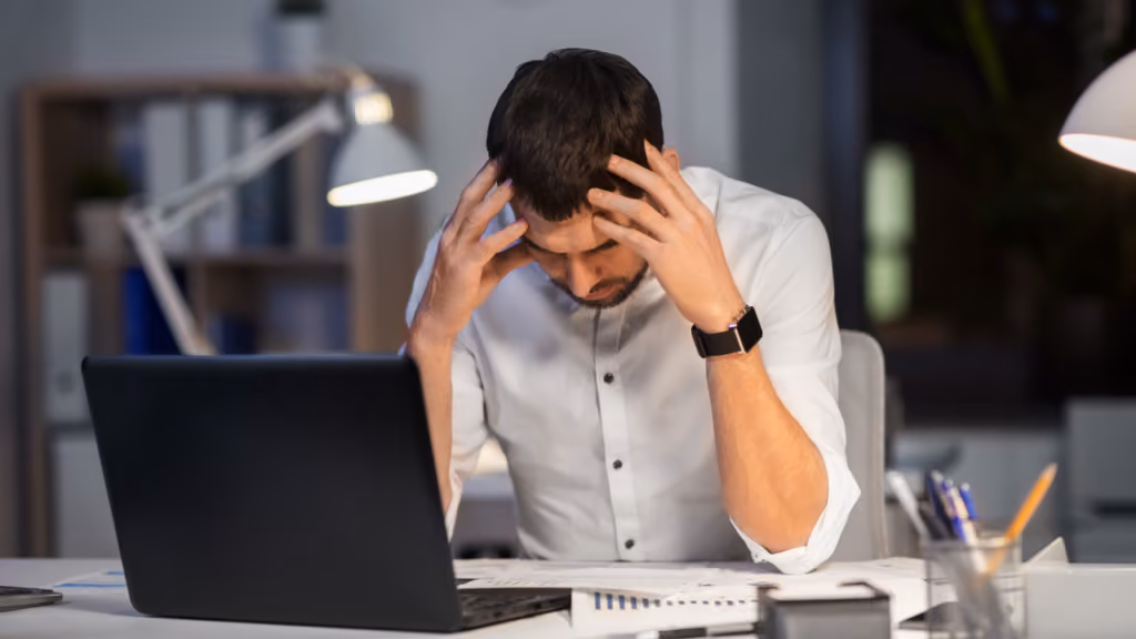Professionnel stressé devant son ordinateur portable