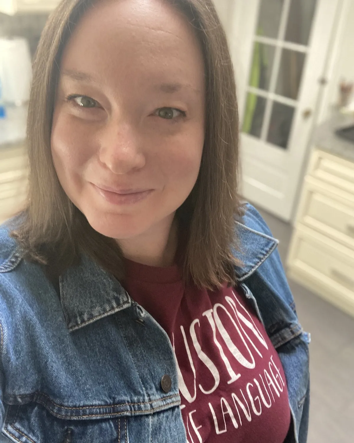 Kelly Henn, smiling, in a denim jacket