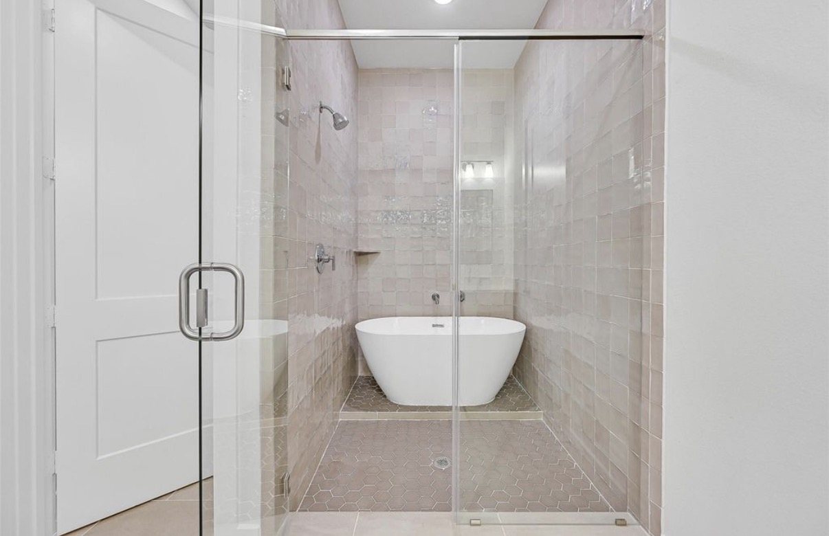 Walk-in shower with a freestanding tub behind glass, completed on schedule