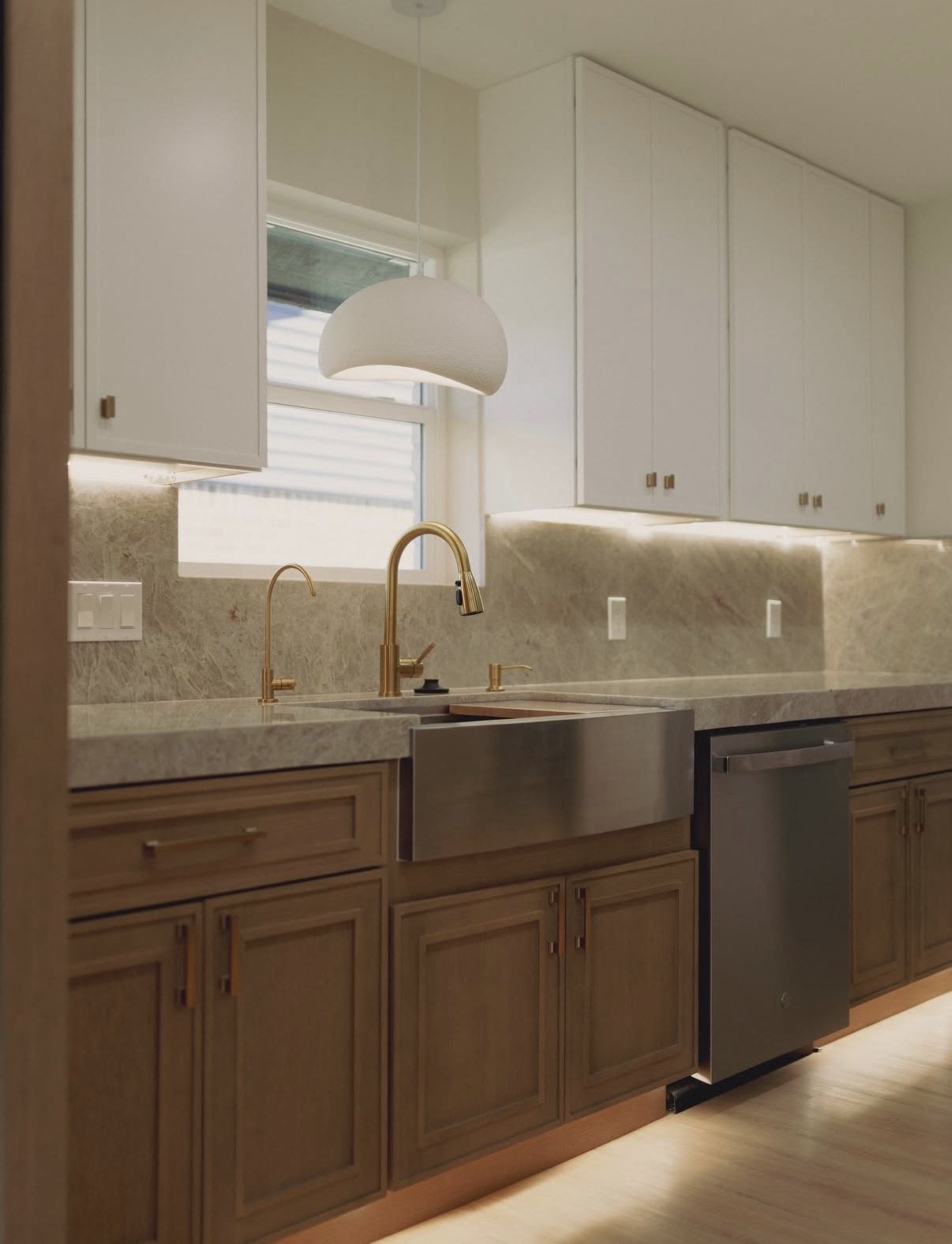 Kitchen with wood cabinetry, a stone counter and a farmhouse sink