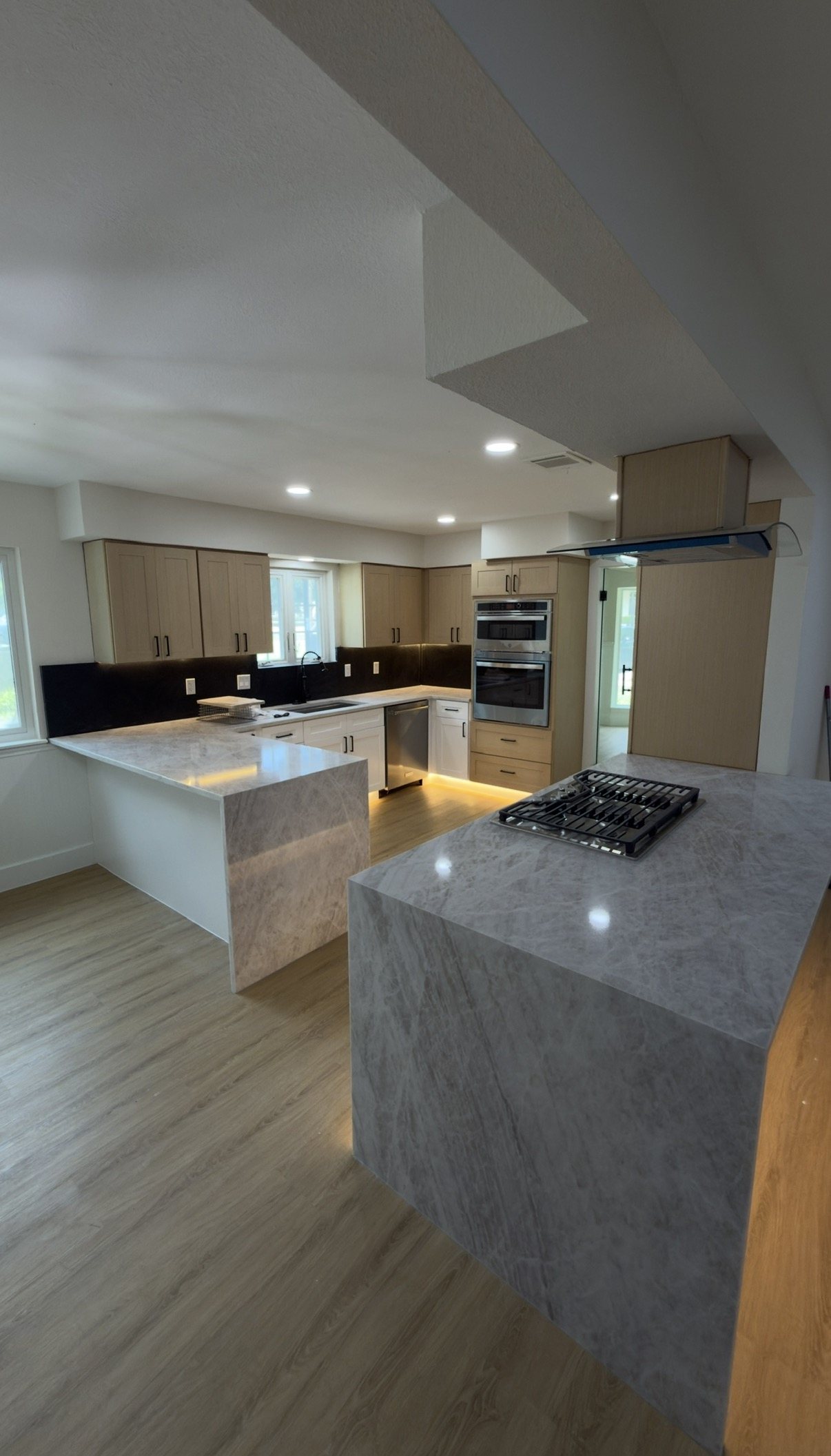 Kitchen island with a thick stone worktop and gas cooktop