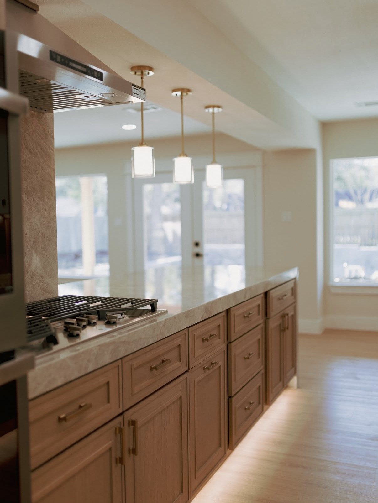 Kitchen with wood cabinetry and a long stone counter run