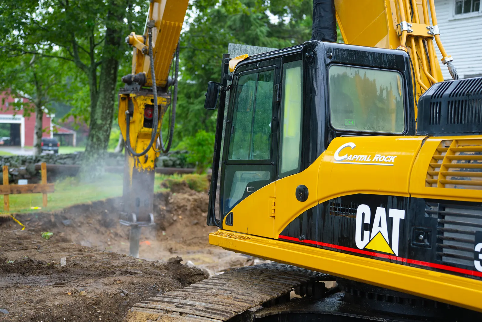 Excavator using a hydraulic breaker on exposed rock