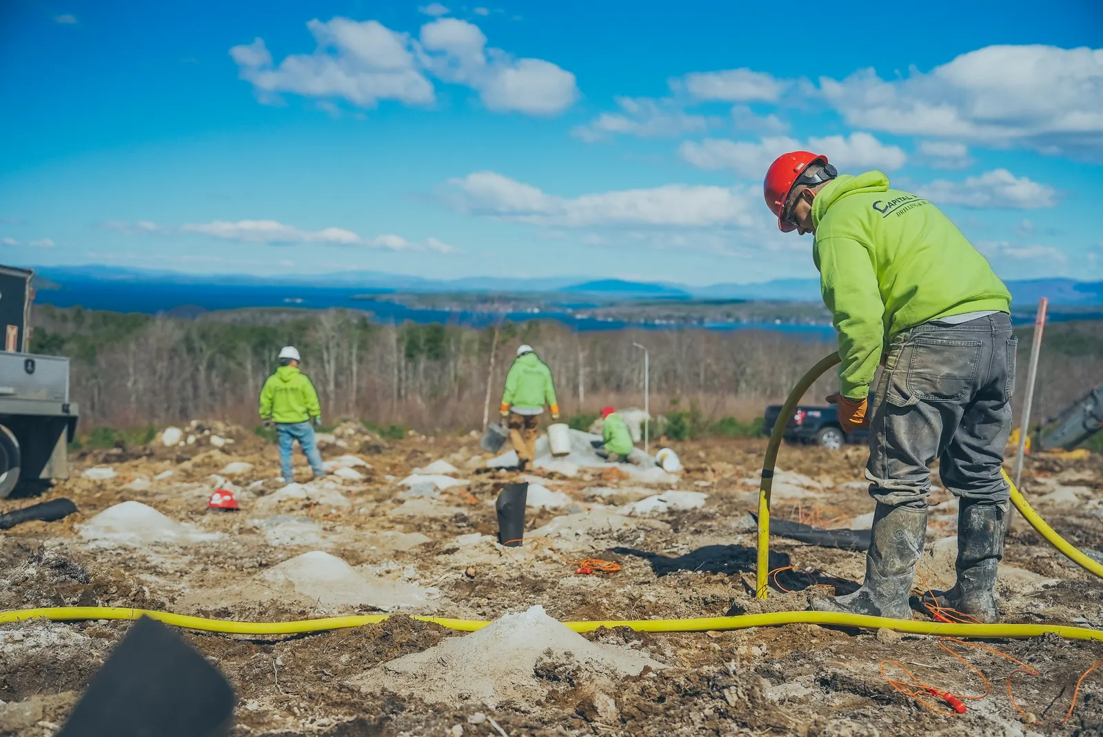 Crew members working together across an exposed rock site