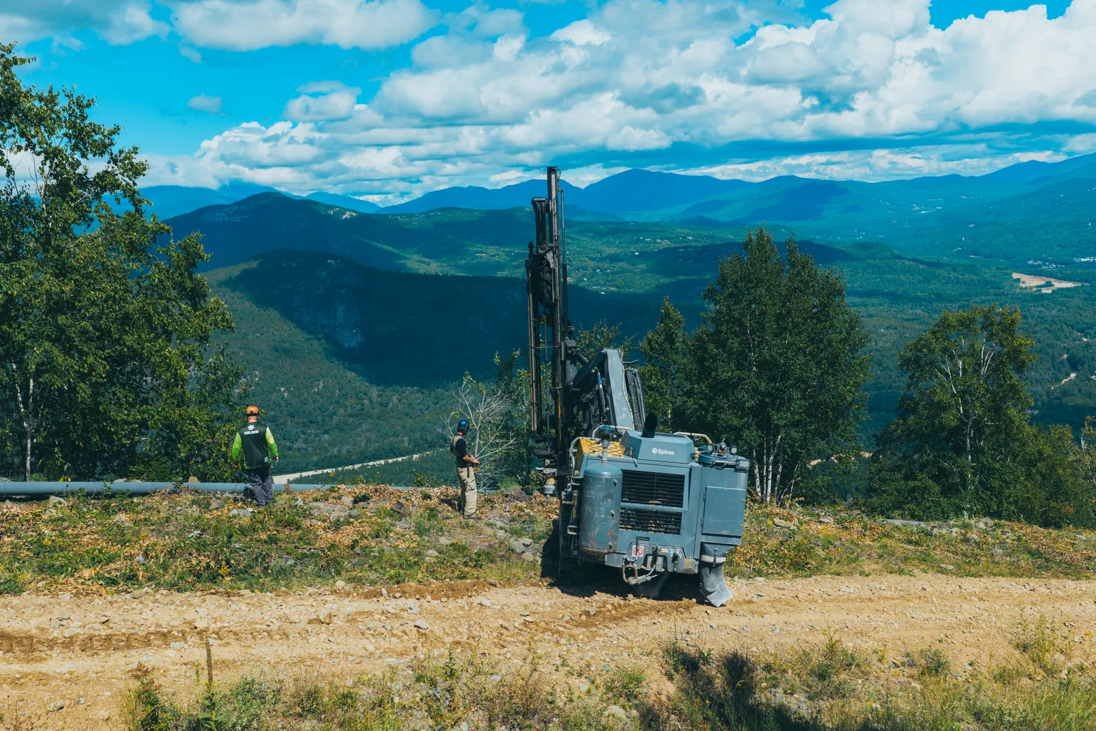 Drill rig and worker on a rocky mountain site