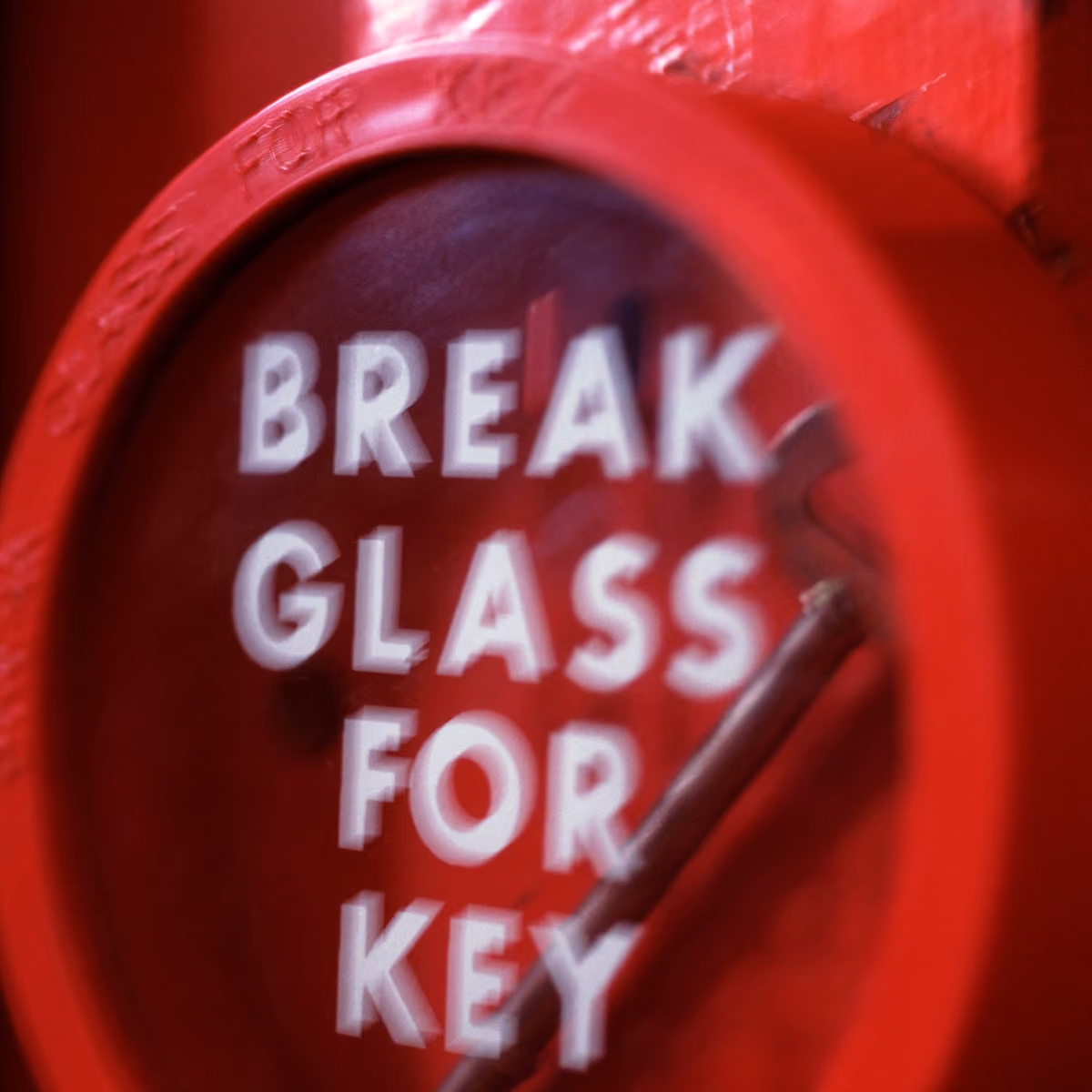 Red emergency box with text 'BREAK GLASS FOR KEY' and a hammer inside.