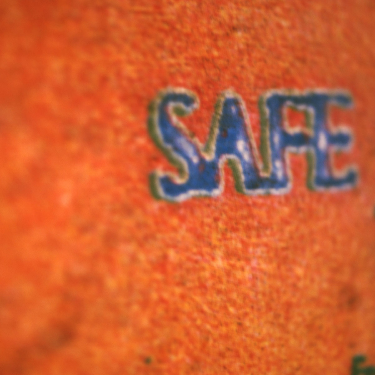 Close-up of a sign with the word PLEASE and colorful paint splatters on it.
