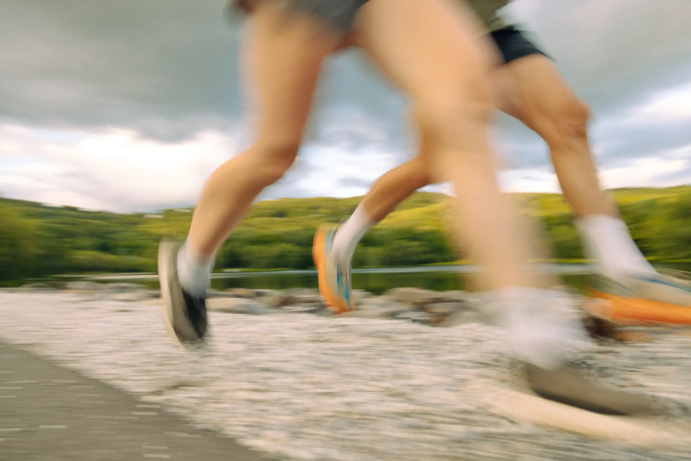 Jambes de coureurs en filé sur un chemin longeant un lac