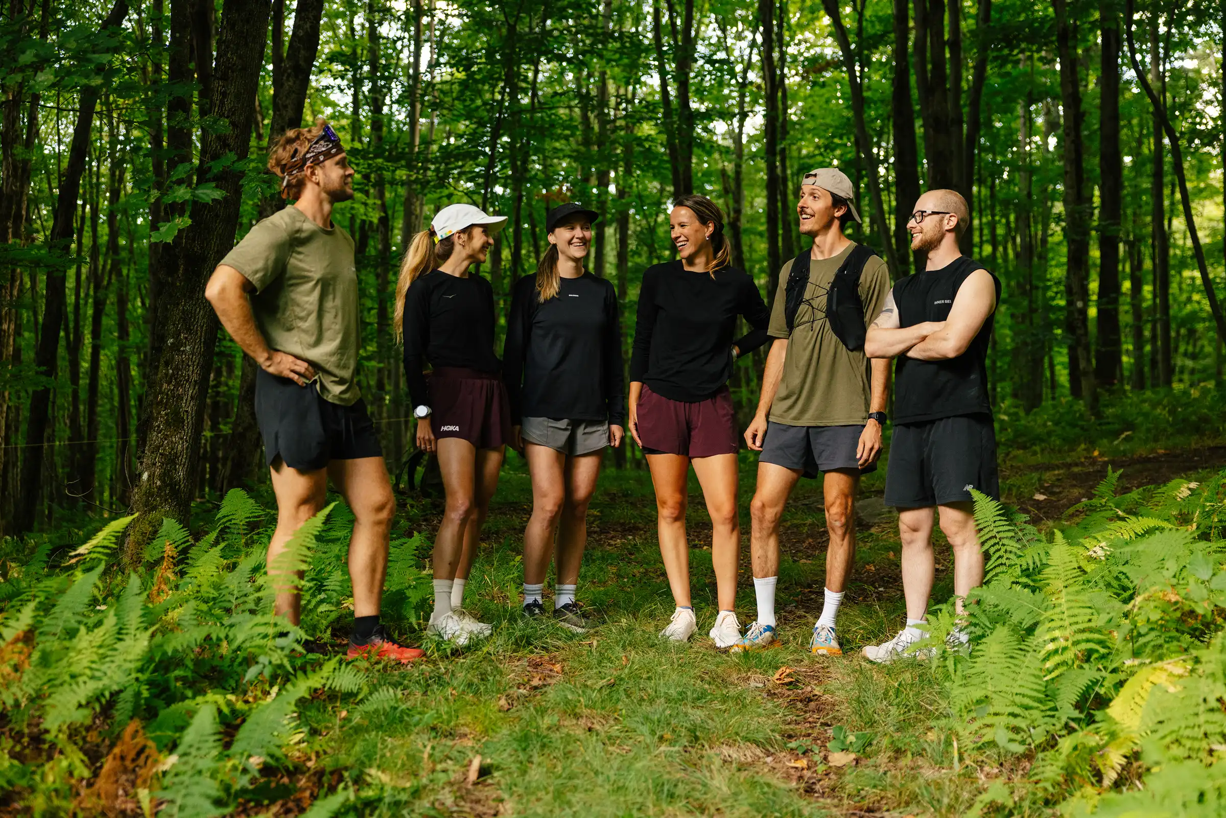 Six coureurs réunis dans une forêt de feuillus