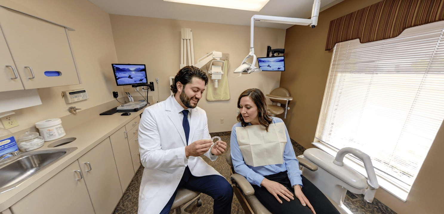 Dentist explains an Invisalign clear aligner to an attentive patient during a consultation.
