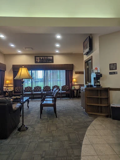 Welcoming waiting area at C. Patrick Gray, DDS in Flint, MI, with warm lighting, comfortable seating, and a wood reception desk