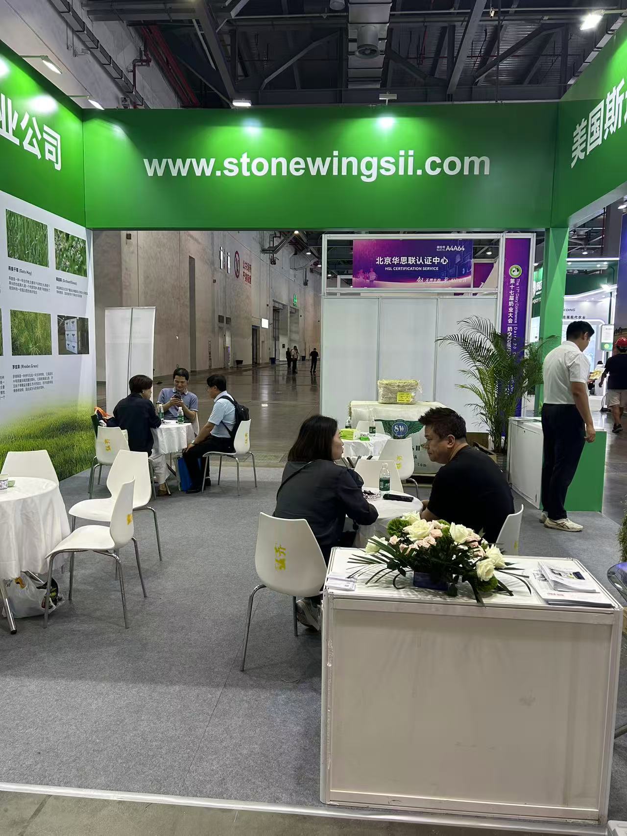 Trade show visitors seated at the Stone Wings II booth in discussion
