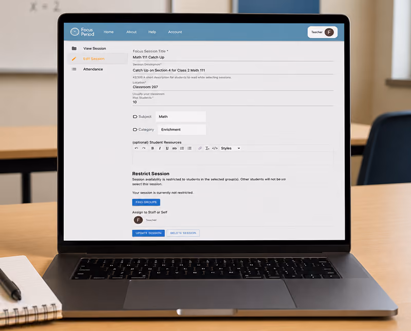 Laptop on a classroom desk displaying a Focus Period session management interface with details for a Math 111 Catch Up session including location, max students, subject, category, and options to restrict session access and assign staff.