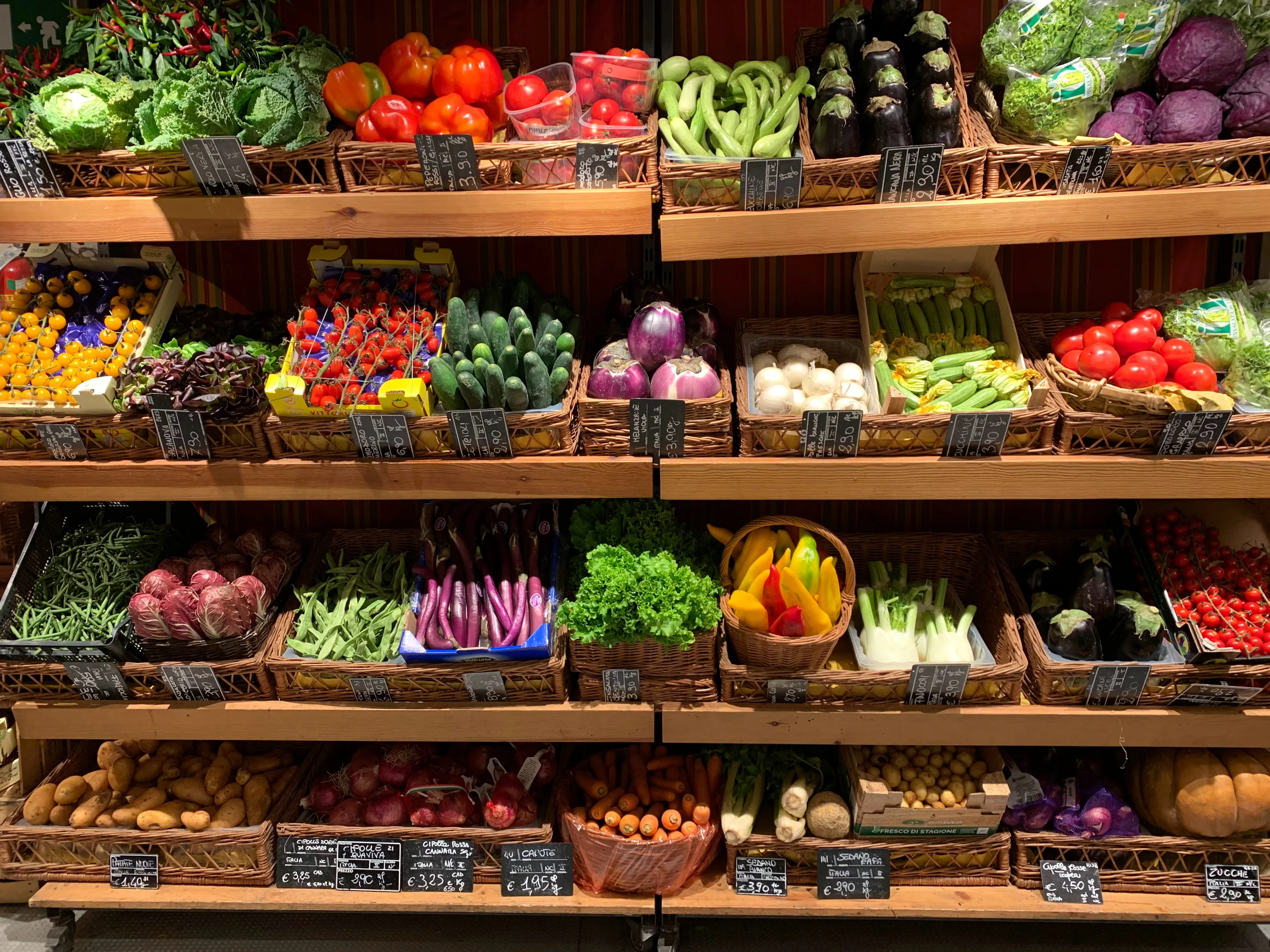 Shelves stocked with fresh vegetables at a grocery store.