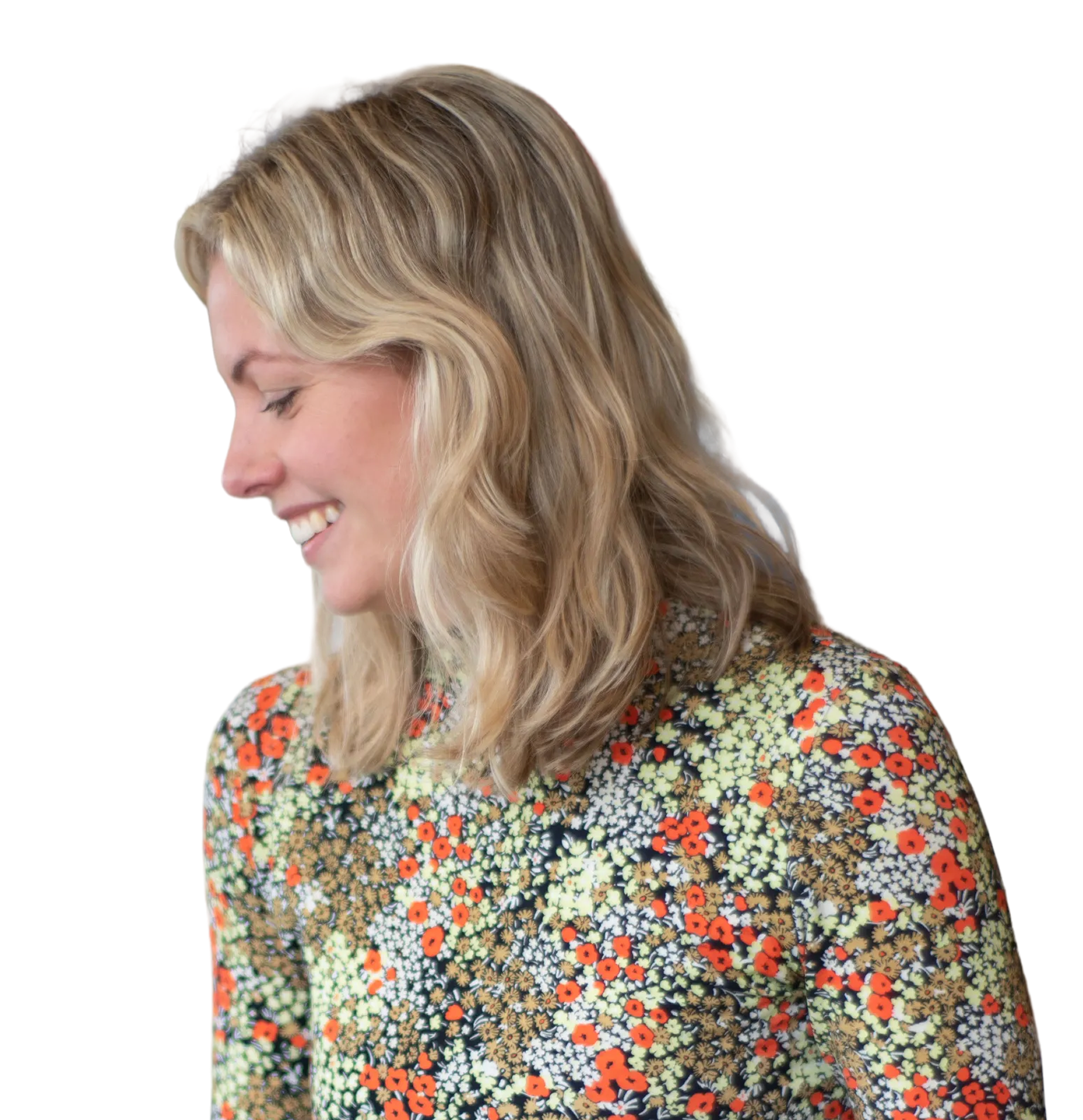 A woman smiling in profile outdoors, framed in an oval