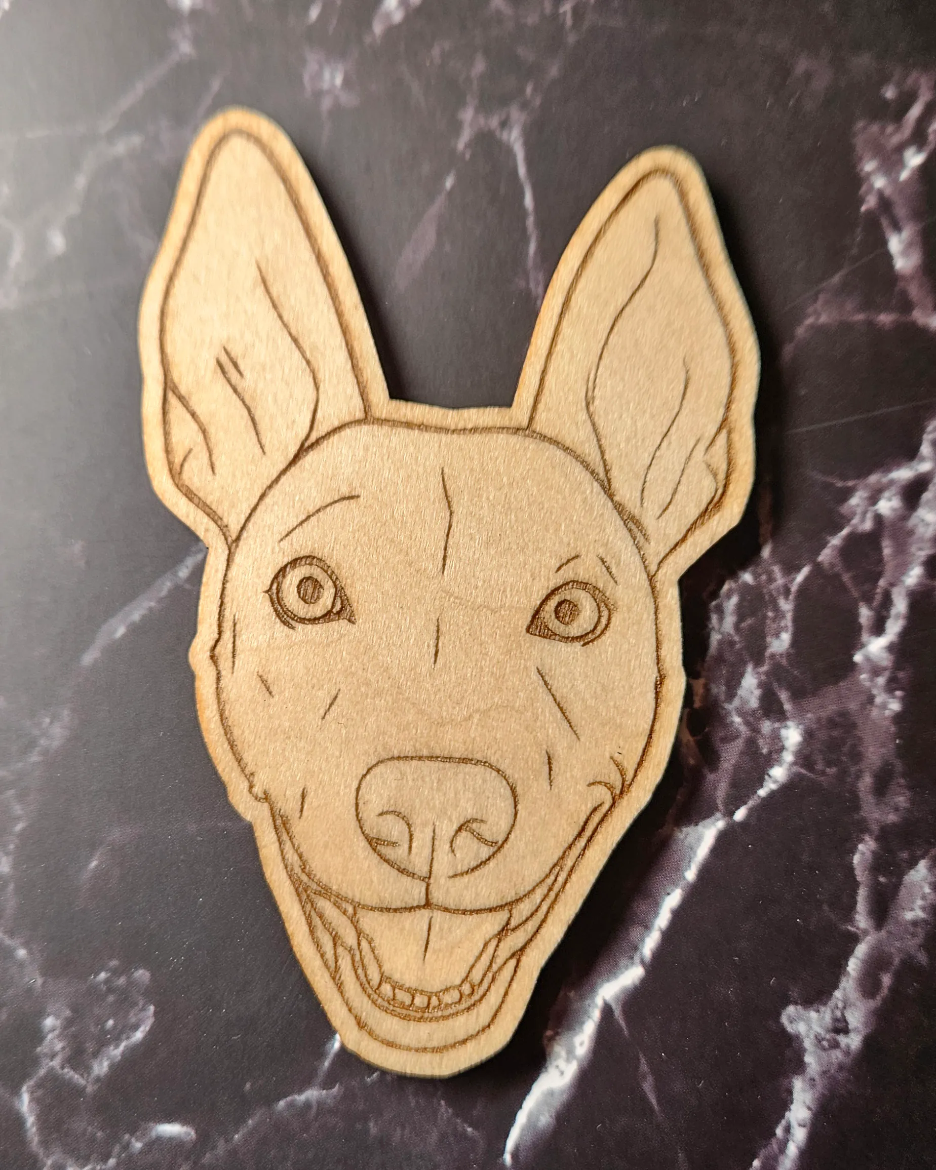 Laser-engraved timber pet portrait magnet of a smiling dog with large upright ears