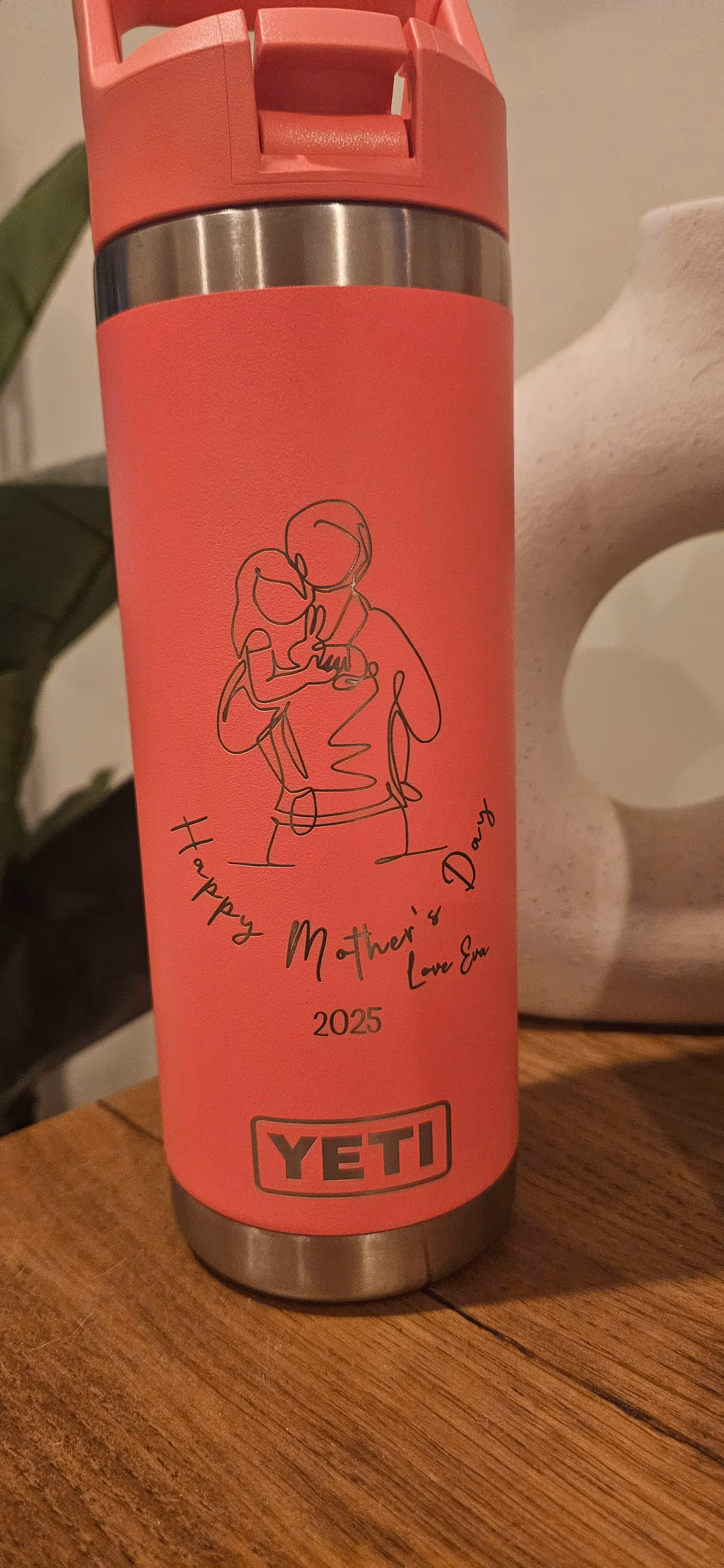 A coral insulated bottle engraved with a child's drawing and a Happy Mother's Day message