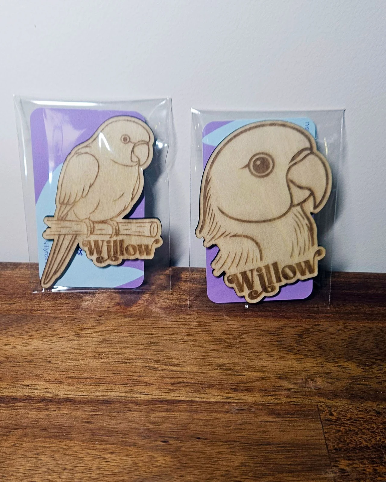 Two engraved timber keepsakes shaped like a pet bird, each named Willow