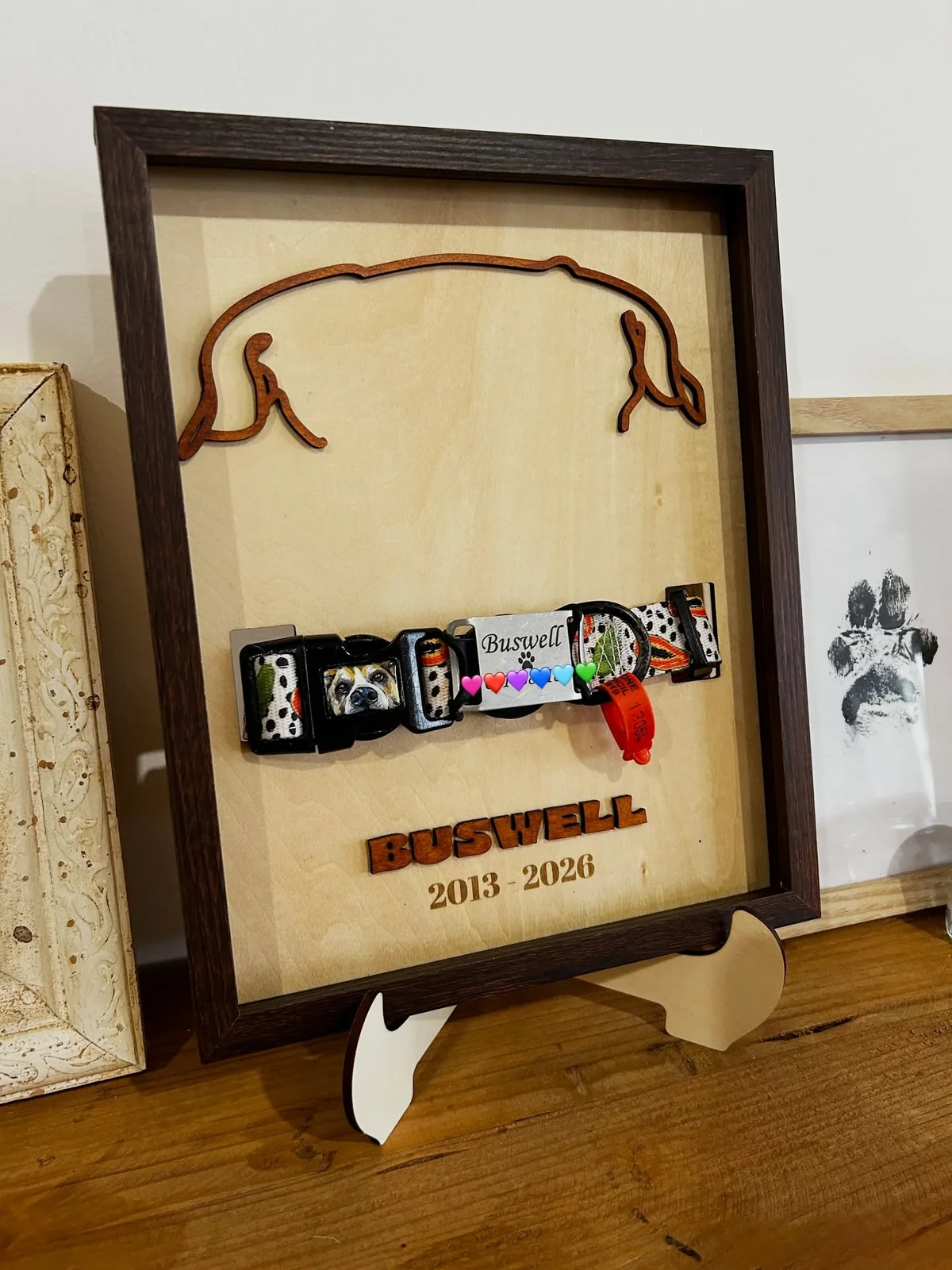 A pet memorial shadow box holding a dog's collar, engraved Boswell 2013 to 2026
