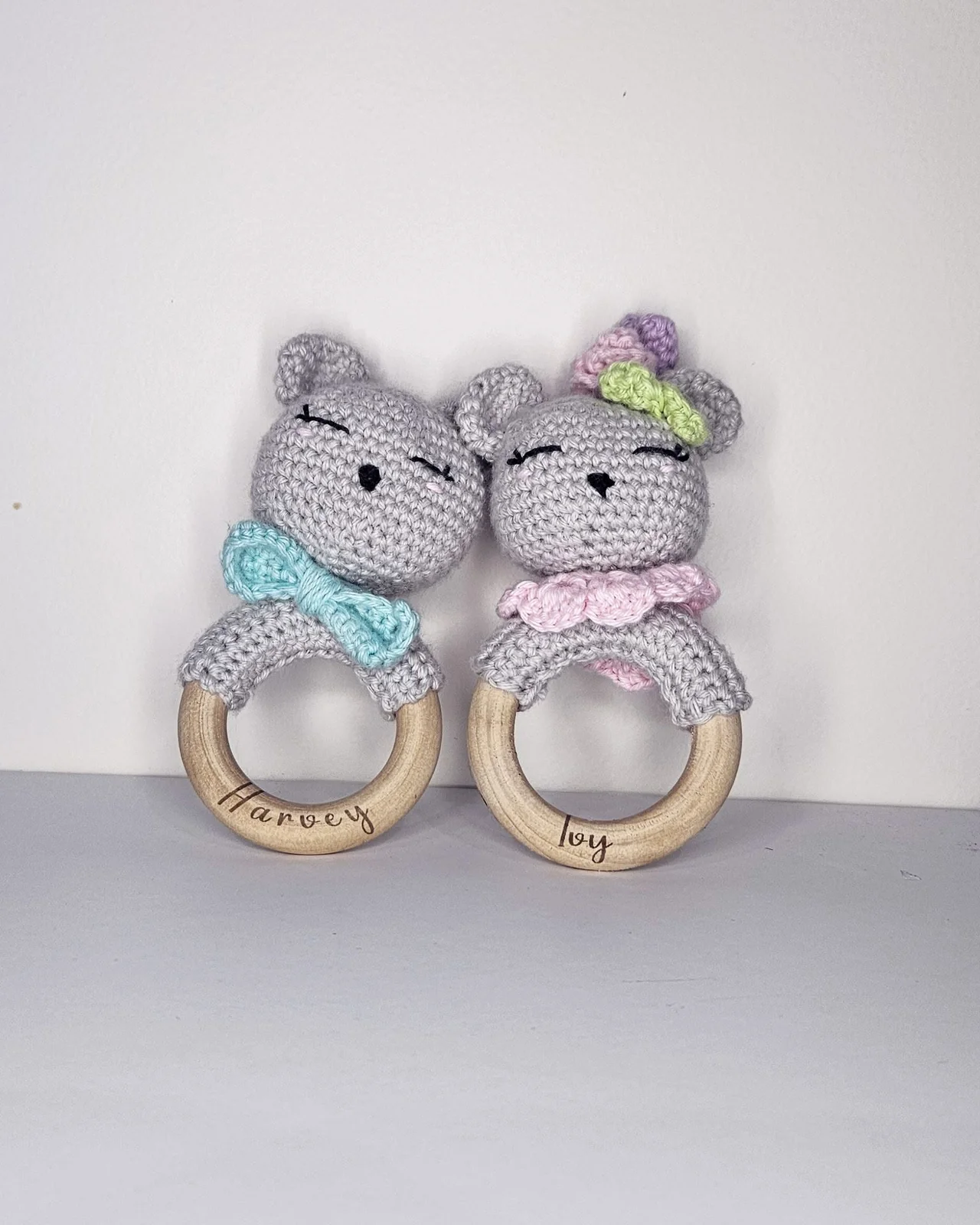 Two wooden teething rattles with crochet bears, engraved Harvey and Ivy