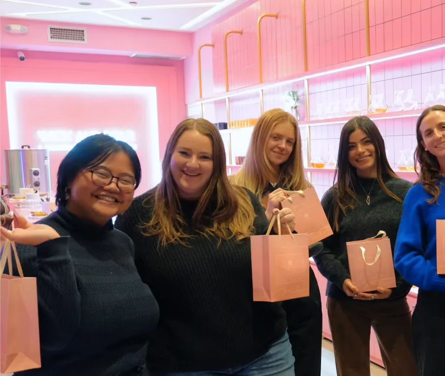 Friends holding Wick & Pour gift bags with their handmade candles after a private event in NYC