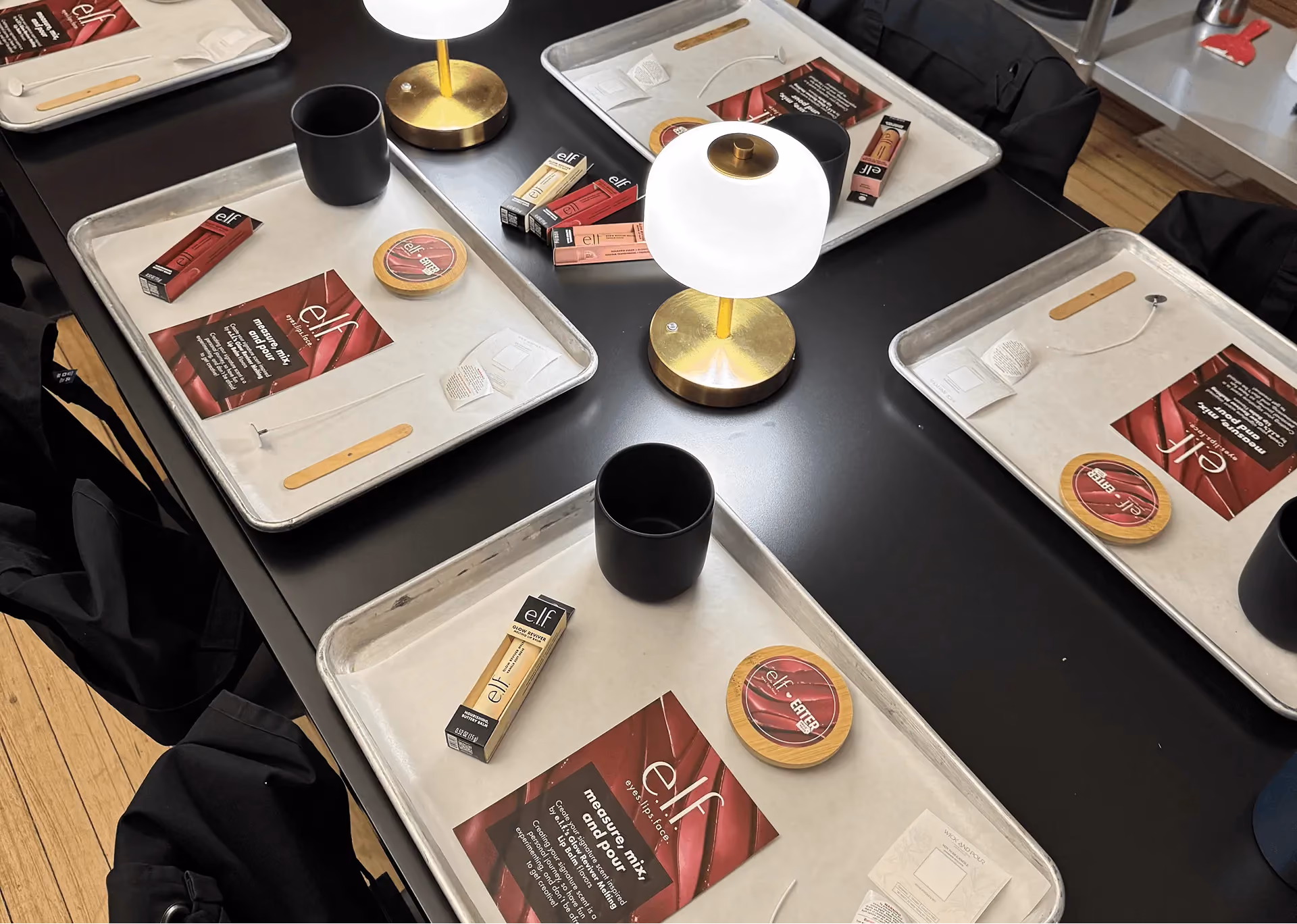 Candle making stations with e.l.f. Cosmetics-branded trays at a Wick & Pour brand activation