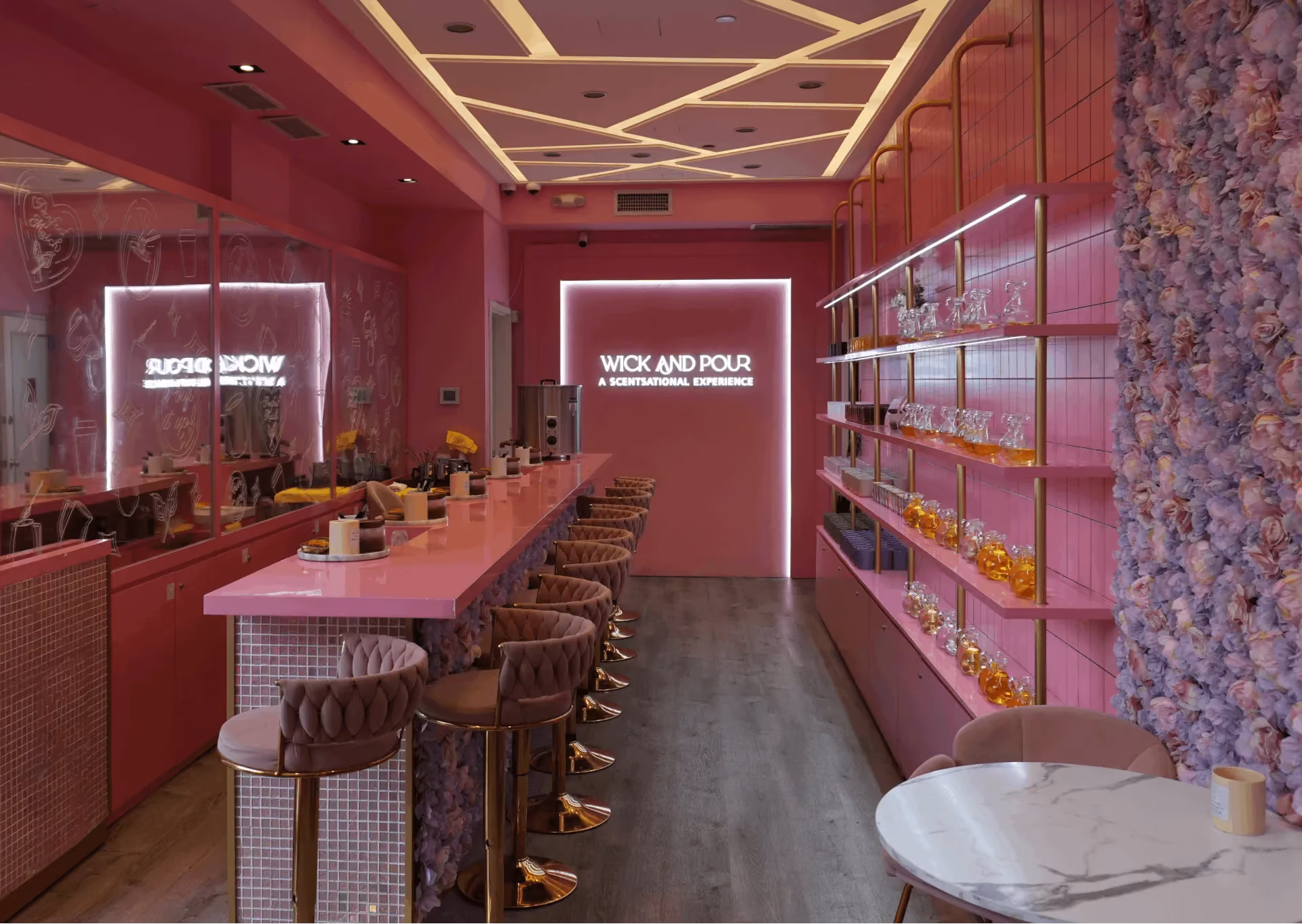 Wick & Pour West Village studio set for a private candle making party, with a pink bar and neon sign