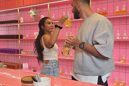 Couple smelling fragrance together at the pink scent bar at Wick & Pour