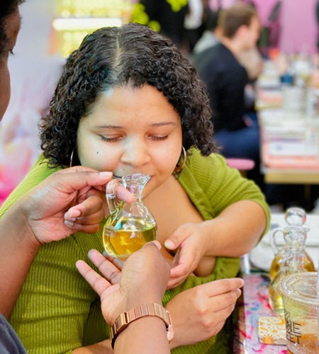 Guest smelling a fragrance oil offered by a Wick & Pour instructor during class