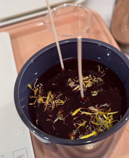Personalized candle with dark wax, dried calendula petals and two wicks at Wick & Pour