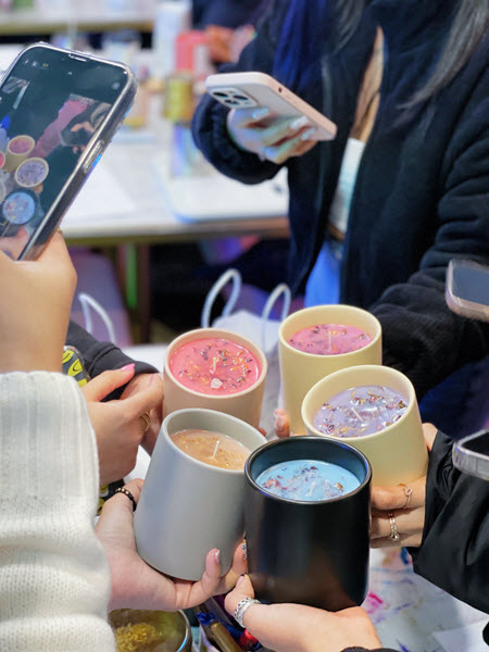 Friends photographing their finished candles after a bachelorette party at Wick & Pour
