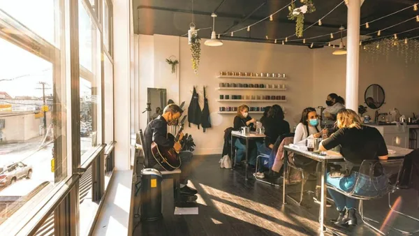 Guests making candles at tables in a sunlit space during a candle making class