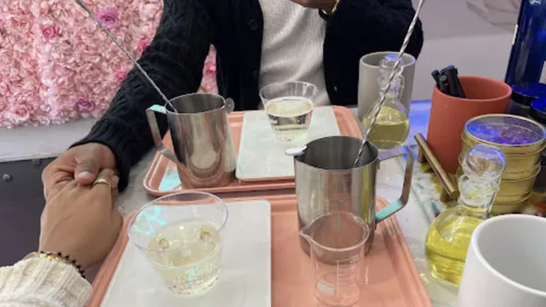 Guests at a candle making tray with steel pitchers, beakers and fragrance oils at Wick & Pour