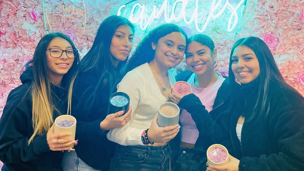 Group of friends smiling with their handmade candles at Wick & Pour in NYC