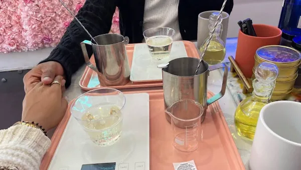 Guests at a candle making tray with pitchers and fragrance oils at Wick & Pour